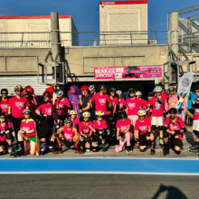 Les équipes Roulez Rose posent devant le box 57
